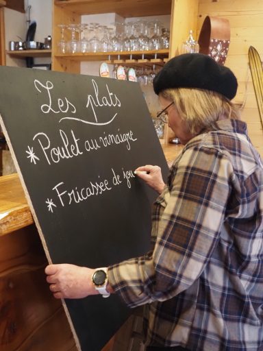 Delphine écrit le menu sur l'ardoise du restaurant